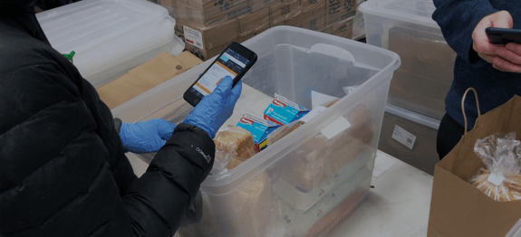 Banner image of hand holding phone with Routeique WMS app for Routeique blog on pivoting supply chain