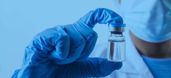 Cover image of hand holding vial of medicine, for Routeique blog on optimizing pharmaceutical distribution